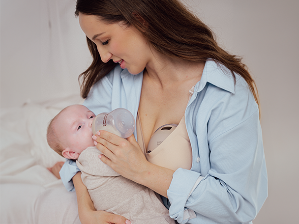 Mama korzystająca z laktatora muszlowego podczas karmienia dziecka