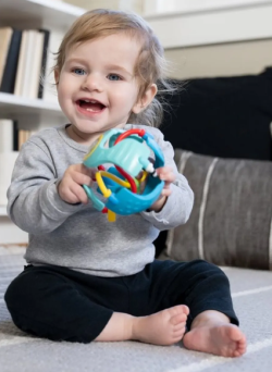 Dziecko trzymające piłkę sensoryczną Baby Einstein Rattle & Sense