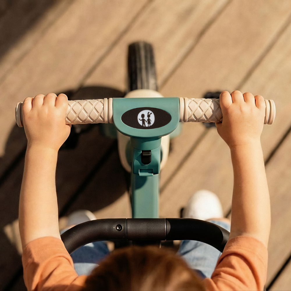 Dziecko trzymające kierownicę rowerka Petite&Mars Turbo Plus