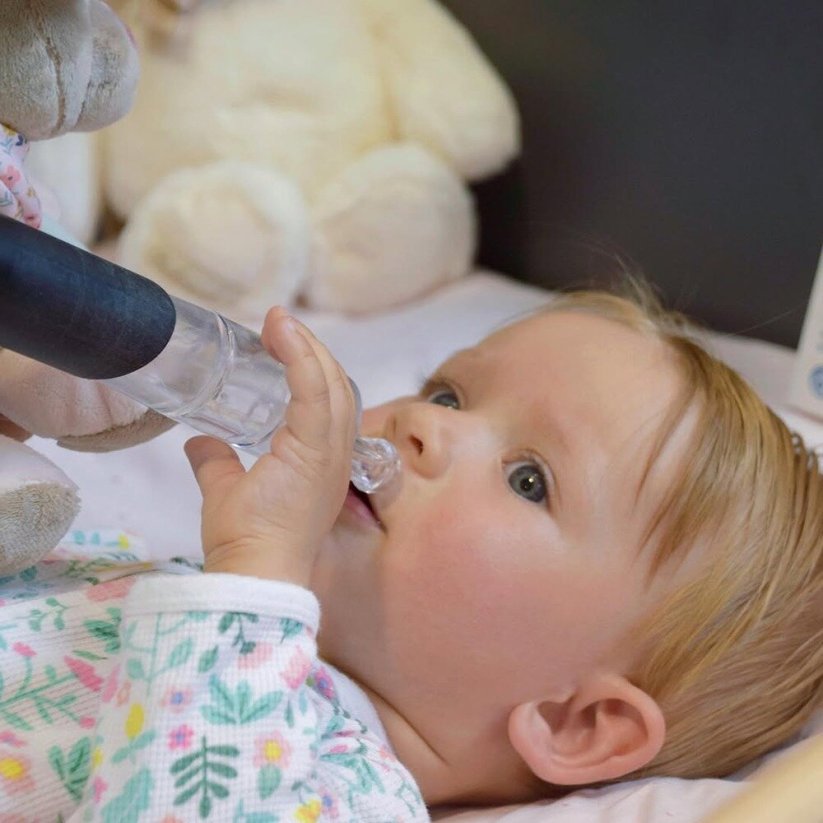 Dziecko trzymające aspirator Petite&Mars Happy Nose