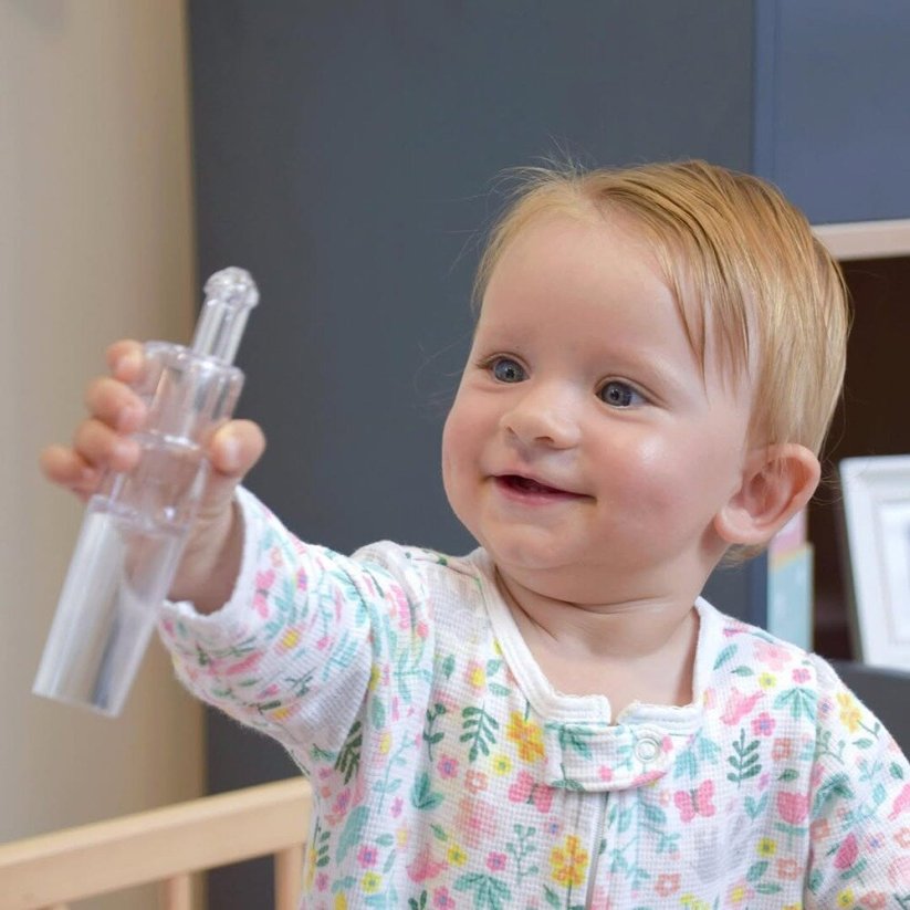 Dziecko trzymające aspirator Petite&Mars Happy Nose